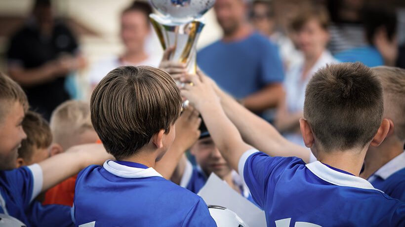 Team of kids celebrating with a trophy